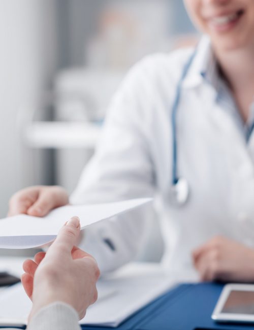 Doctor giving a prescription Female doctor meeting with a patient in the office, she is giving a prescription to the woman, healthcare and medicine concept